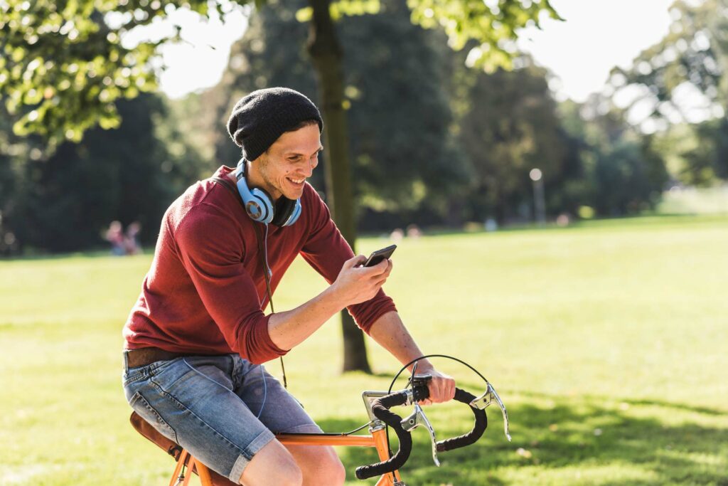 Mit Kopfhörer und Handy auf dem Fahrrad ohne Helm - ein enormes Sicherheitsrisiko.